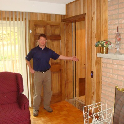 Steve gesturing to a newly installed elevator by Canada Elevators