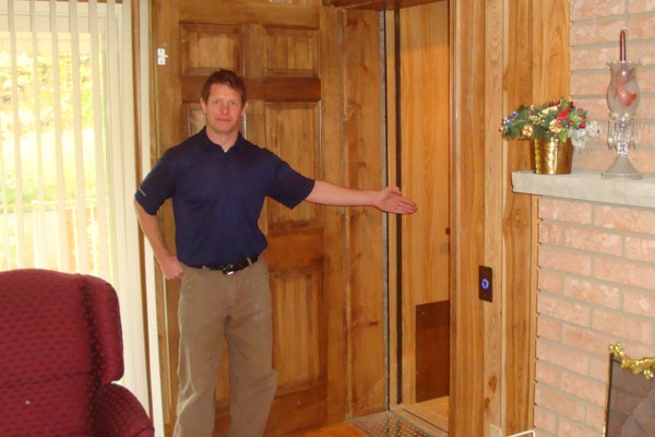 Steve gesturing to a newly installed elevator by Canada Elevators